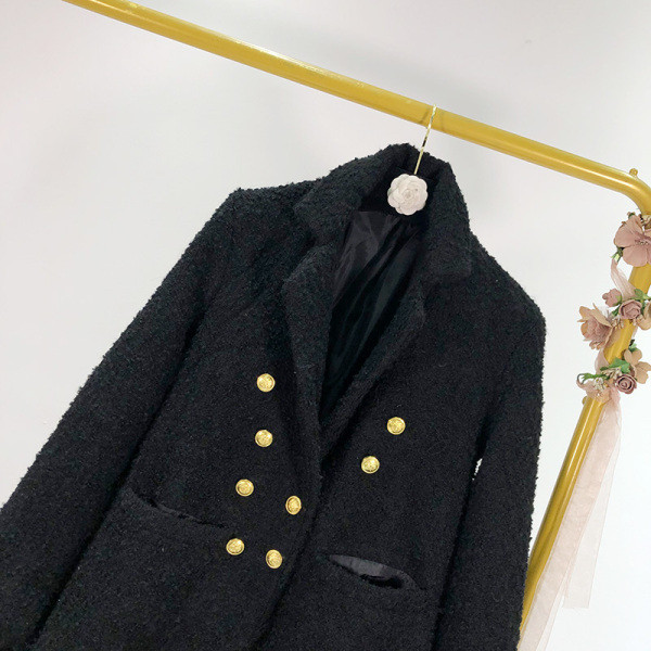 Hosszú, elegáns fekete kabát kétsoros rögzítéssel és zsebekkel