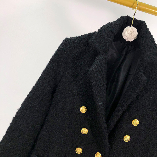 Hosszú, elegáns fekete kabát kétsoros rögzítéssel és zsebekkel