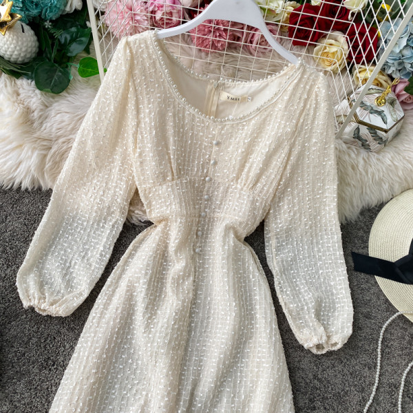 Stílusos női ruha fekete és bézs színben, gombokkal és hosszú ujjal