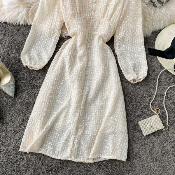 Stílusos női ruha fekete és bézs színben, gombokkal és hosszú ujjal