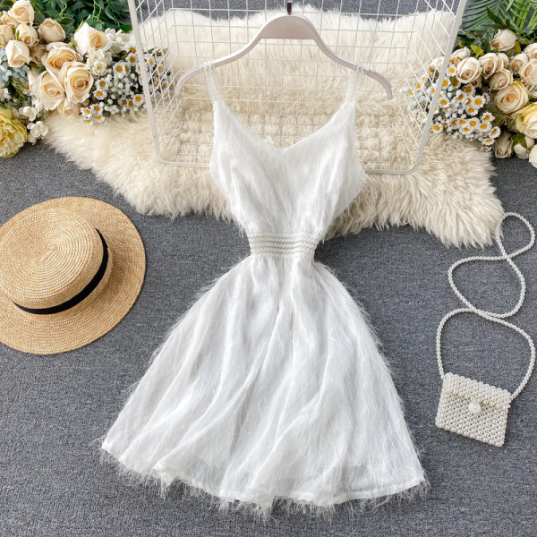 Κομψό γυναικείο φόρεμα με κρόσσια και λεπτούς ιμάντες ώμου σε μαύρο και άσπρο χρώμα