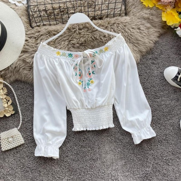 Új modell női blúz csónakos nyakkivágással, nyakkendőkkel és kék hímzéssel