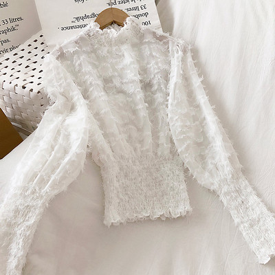 Bézs, fekete-fehér női blúz magas gallérral és bojttal