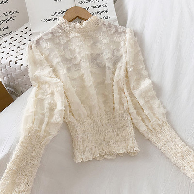 Bézs, fekete-fehér női blúz magas gallérral és bojttal