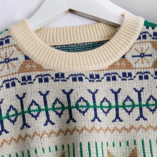 Modern női pulóver ovális nyakkivágással és színes mintával fekete-fehérben