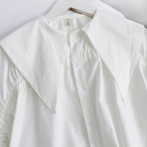 Modern női ing gombokkal és nyakkendőkkel a kézen aszimmetrikus fehér modell