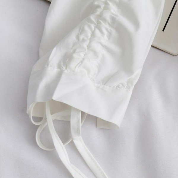 Modern női ing gombokkal és nyakkendőkkel a kézen aszimmetrikus fehér modell