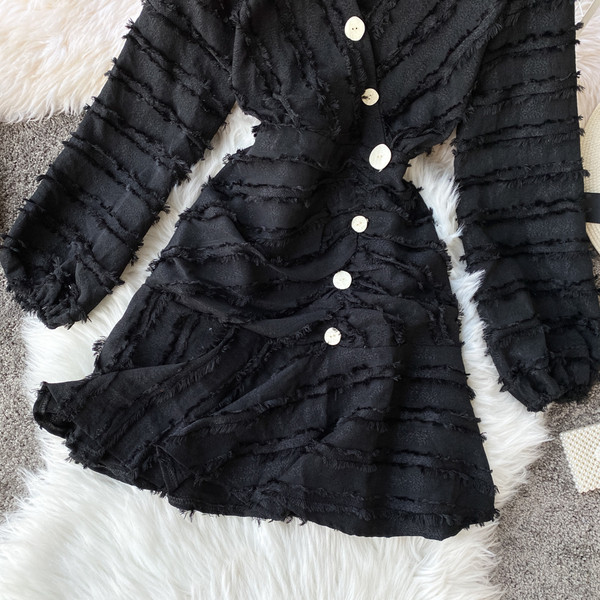 Modern női ruha fekete és bézs színben V-nyakkal és gombokkal