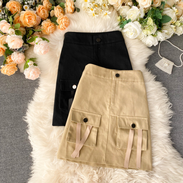 Paprastas moteriškas sijonas aukštu juosmeniu ir smėlio bei juodos spalvos kišenėmis