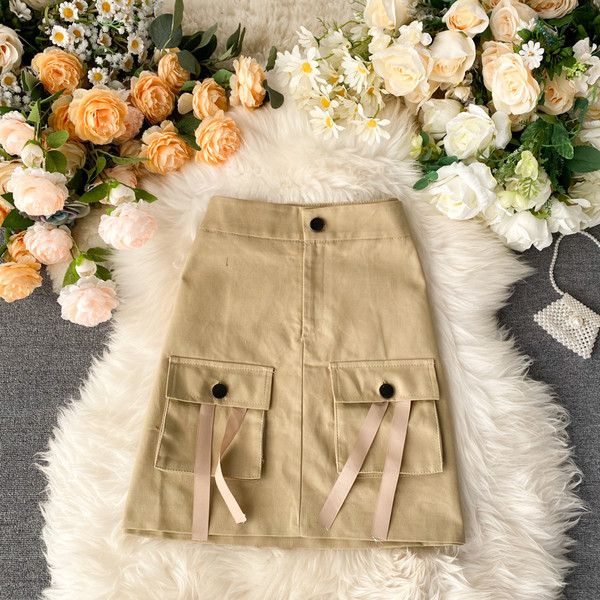 Paprastas moteriškas sijonas aukštu juosmeniu ir smėlio bei juodos spalvos kišenėmis