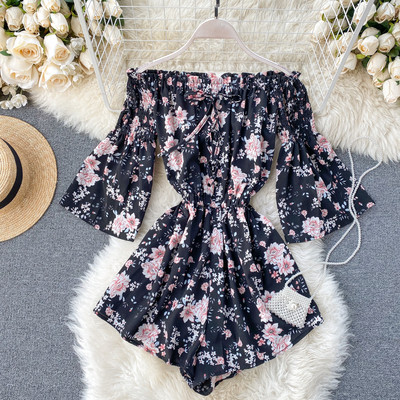 Kelių spalvų modernus moteriškas kombinezonas apnuogintais pečiais ir gėlių raštu