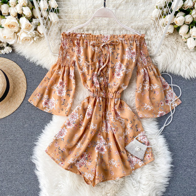 Kelių spalvų modernus moteriškas kombinezonas apnuogintais pečiais ir gėlių raštu