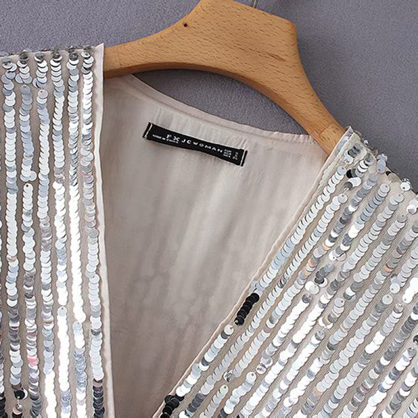 Modern női blúz mély V-nyakkal és flitterekkel