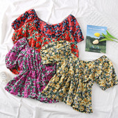 Színes női blúz csónakos nyakkivágással és virágmotívumokkal
