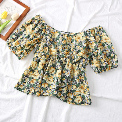 Színes női blúz csónakos nyakkivágással és virágmotívumokkal