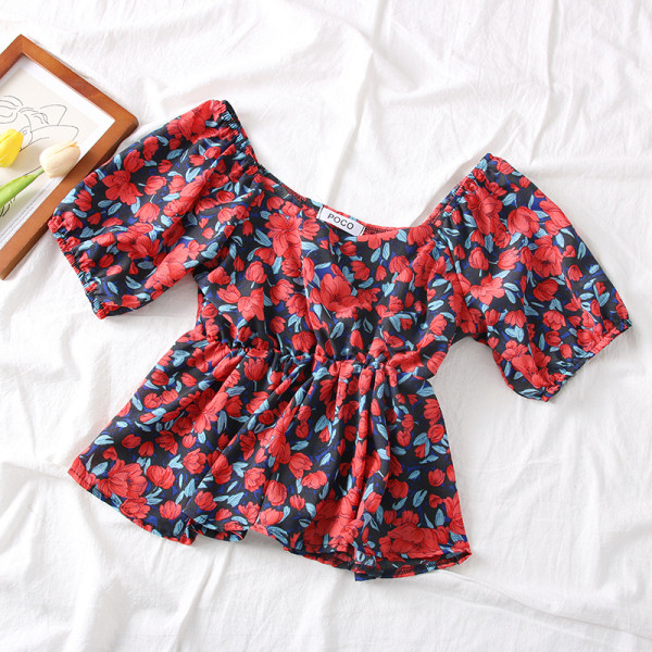 Színes női blúz csónakos nyakkivágással és virágmotívumokkal