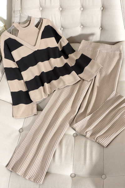 Modern női szett, amely egy csupasz vállú pulóvert és magas derékú, redőzött nadrágot tartalmaz