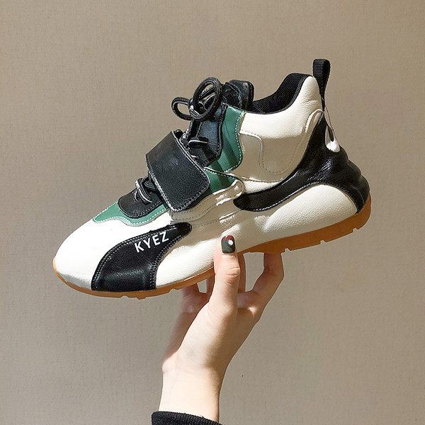 Eko bőrből készült magas női tornacipő lapos talppal, matricákkal és megkötősekkel