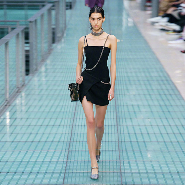 Lühike musta kleidiga liibuv mudel õhukeste rihmade ja metallkettidega